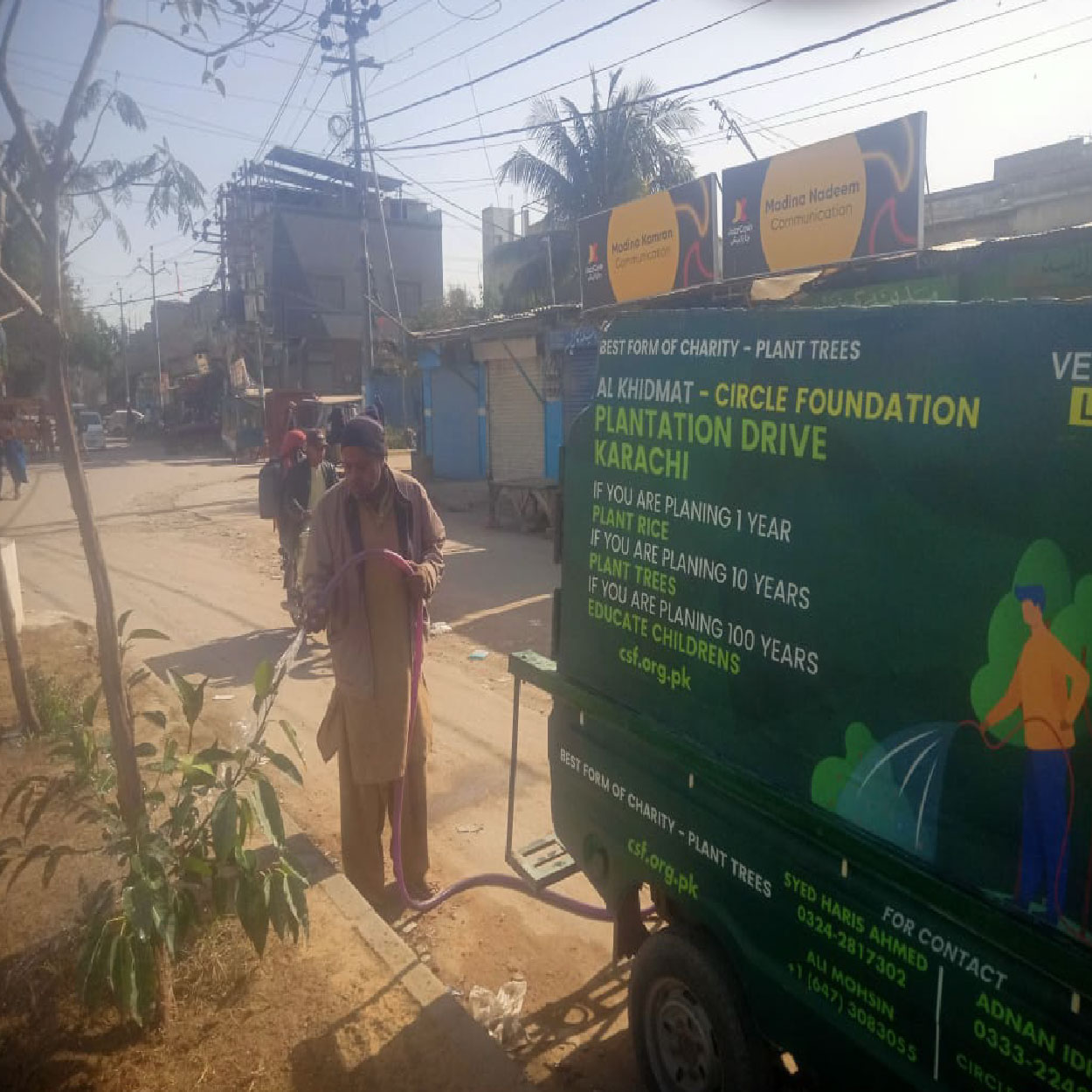 CSF plantation drive team watering newly planted trees on street using branded plantation drive vehicle for environmental sustainability in Karachi